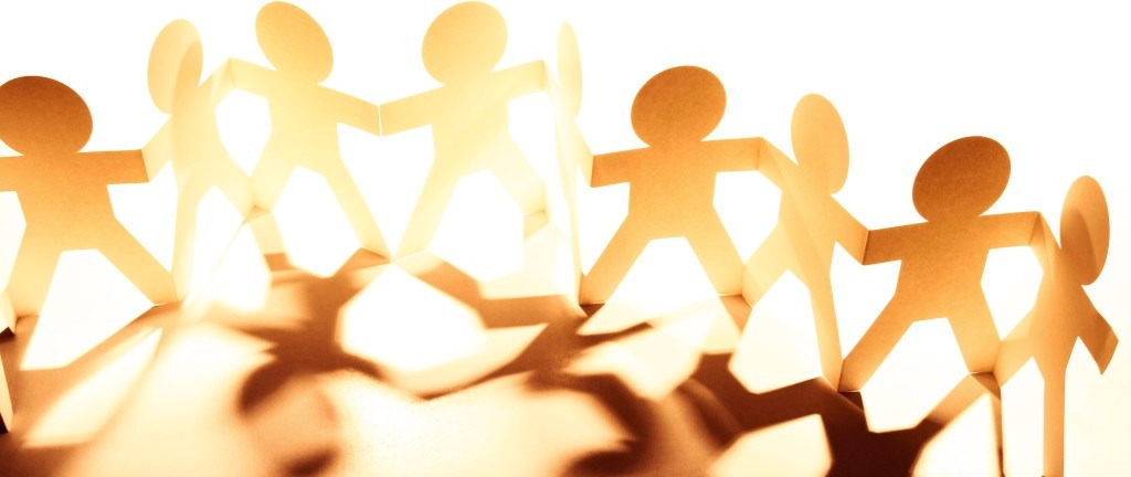 Team of paper doll people holding hands
