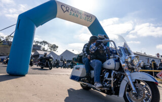 Motorcyclist riding under the Alzheimer's San Diego Rides4ALZ archway