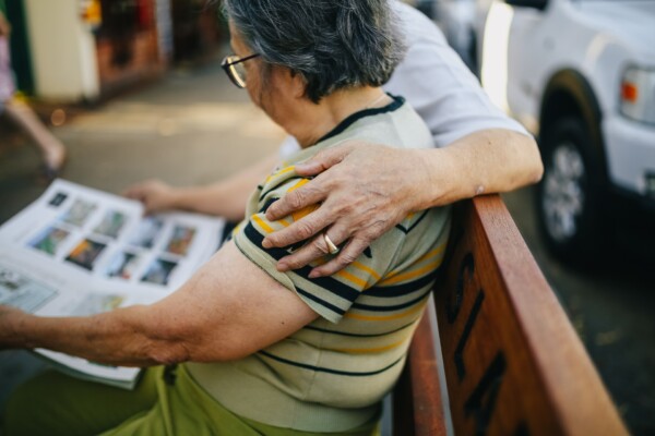 Man hugging partner on bench